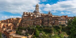 Scenic view of Siena in Tuscany, featuring the iconic cathedral and hillside buildings, as seen in Stanley Tucci’s Tuscany episode exploring traditional Italian food culture.
