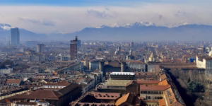 Panoramic view of Turin, Italy, with the Mole Antonelliana rising above elegant 19th-century architecture and the snow-capped Alps in the background—capturing Piedmont’s historic and cultural heart.
