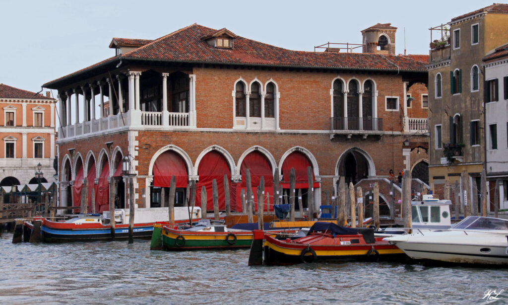 Rialto Fish Market building with red awnings on the Grand Canal in Venice, Italy