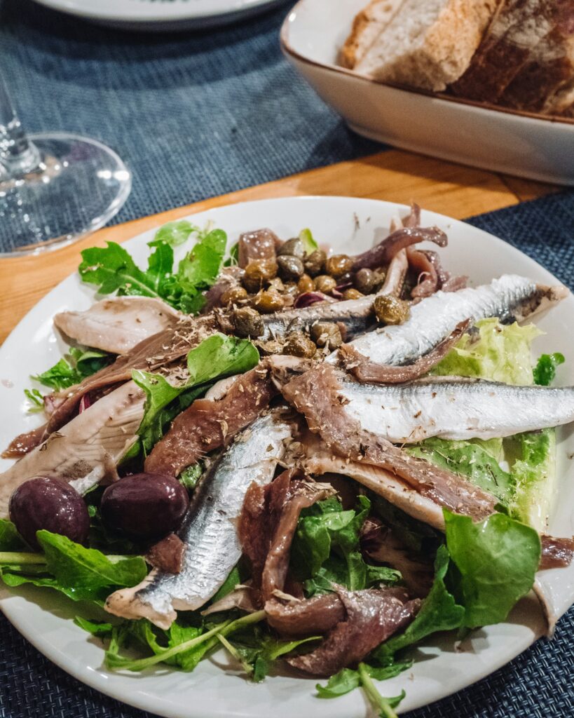 Anchovy salad with olives and capers, reflecting the seafood-focused pintxos culture featured in Somebody Feed Phil Basque Country.