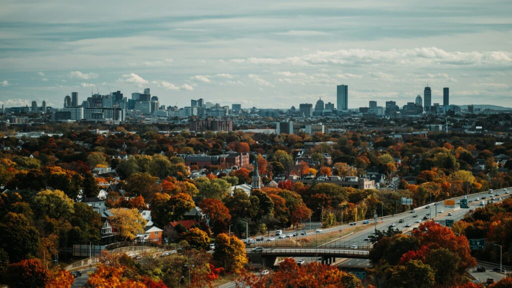 Boston skyline with vibrant autumn foliage in the foreground, capturing the city’s multicultural spirit featured in Somebody Feed Phil Boston.