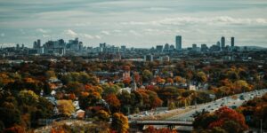 Boston skyline with vibrant autumn foliage in the foreground, capturing the city’s multicultural spirit featured in Somebody Feed Phil Boston.