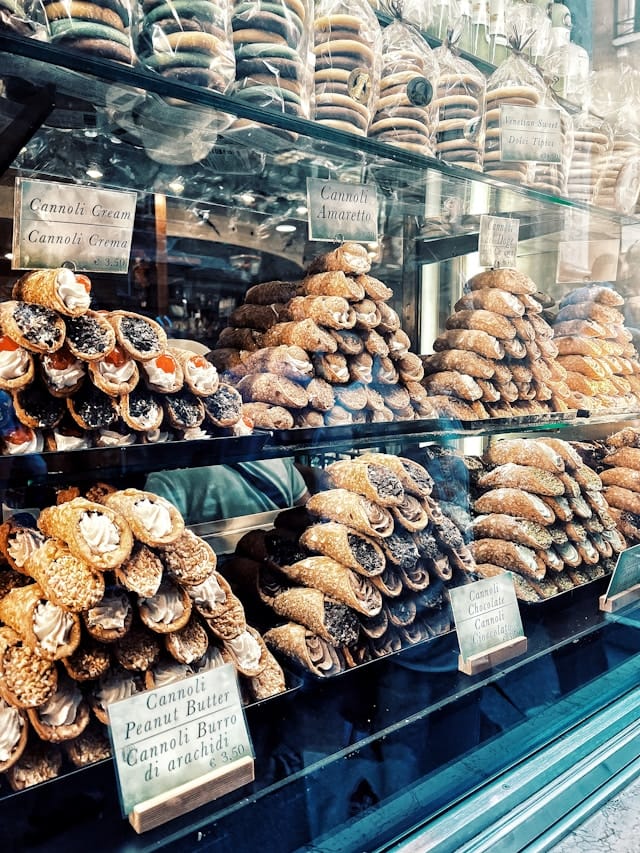 Traditional Sicilian cannoli in a pastry shop window, highlighting the island’s sweet heritage in Stanley Tucci’s food journey.