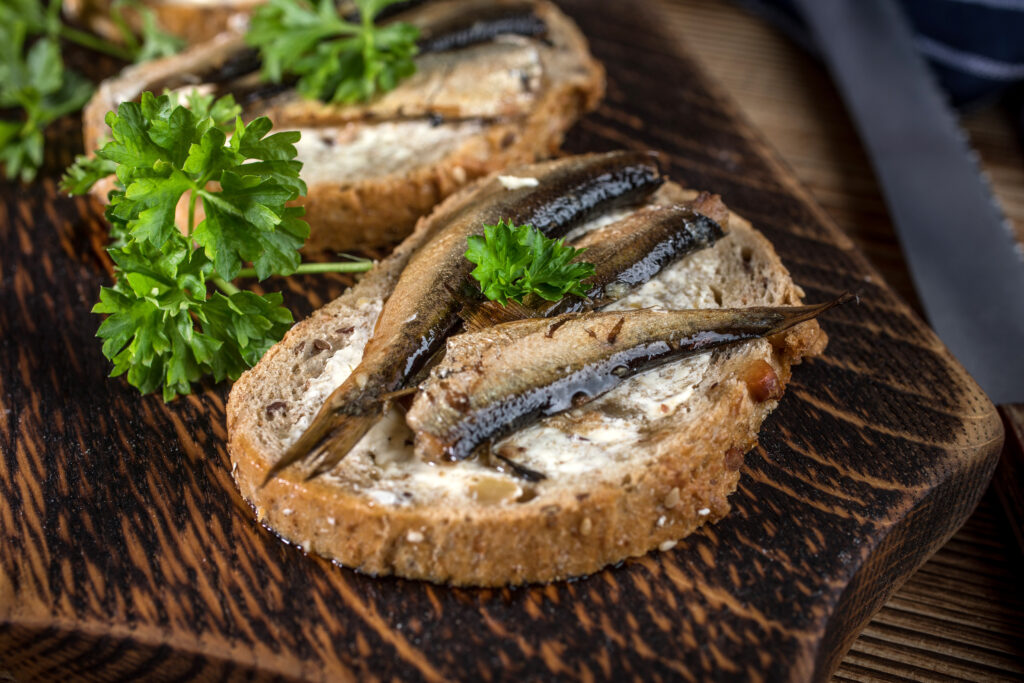 Slices of raw herring served on rye bread with butter and parsley — a nod to Amsterdam’s classic street snack featured in Somebody Feed Phil Amsterdam.
