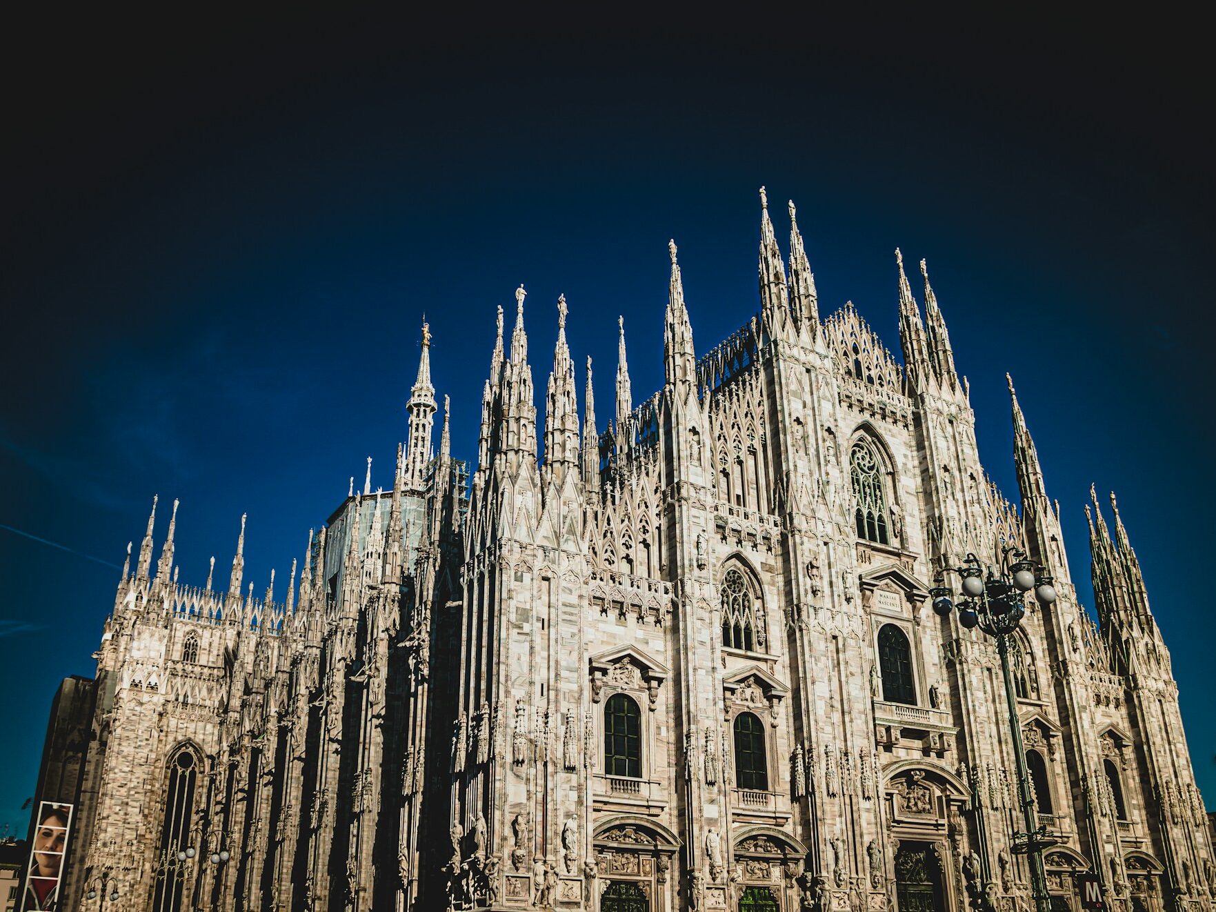 The Duomo di Milano under a clear blue sky — a symbol of Milan’s cultural richness featured in Stanley Tucci’s Italian food journey.