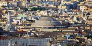 A panoramic view of Rome’s historic cityscape featuring the Pantheon’s iconic dome surrounded by a dense mosaic of pastel-colored buildings