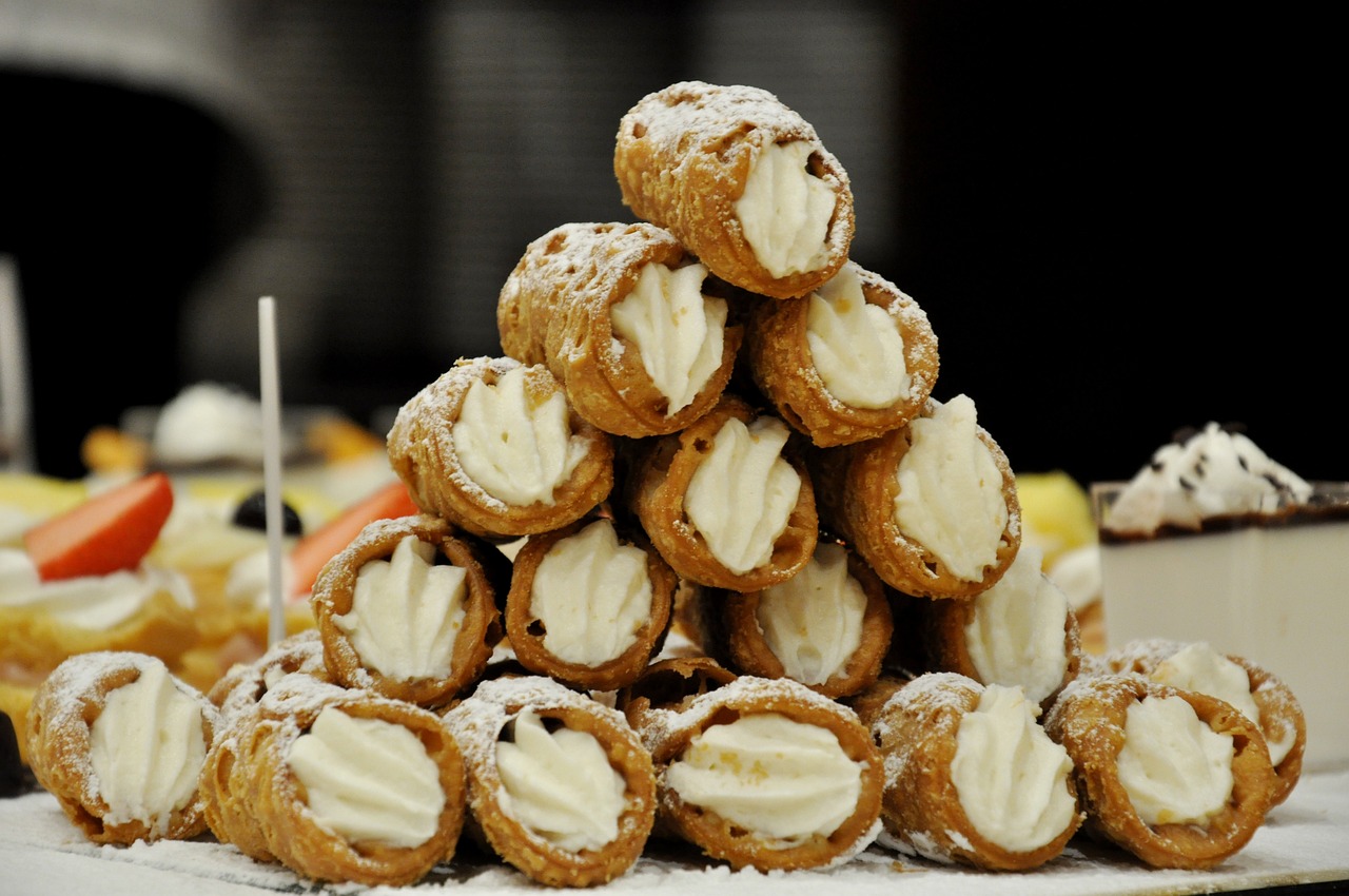 Stack of freshly filled cannoli with powdered sugar, representing Boston’s North End Italian pastry tradition featured in Somebody Feed Phil Boston.