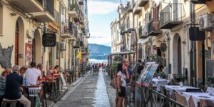 Charming street view of coastal Sicily, where Stanley Tucci discovers regional flavors and cultural richness in Searching for Italy.