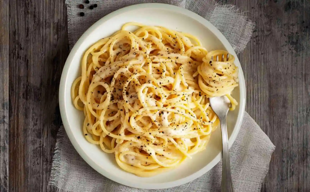 Plate of Cacio e Pepe pasta topped with cracked black pepper