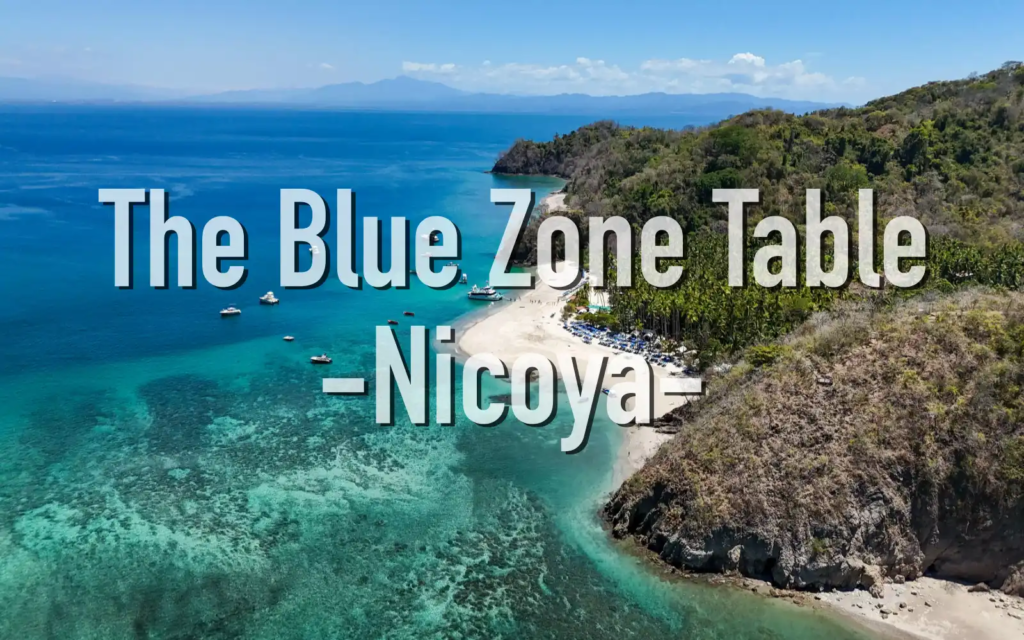 Aerial view of the Nicoya Peninsula coastline in Costa Rica, featuring turquoise waters, a sandy beach, and lush green hills—representing one of the world’s Blue Zones.