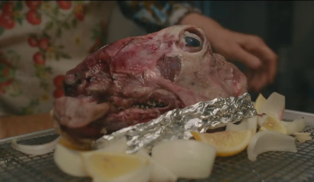 Raw sheep’s head surrounded by onions and lemon wedges, ready for Capuzzelle preparation in movie Nonnas