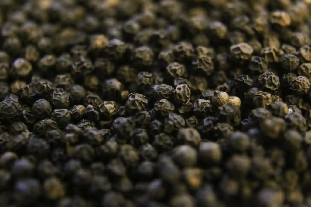 Close-up shot of whole black peppercorns showing their textured surface