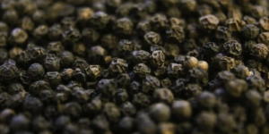 Close-up shot of whole black peppercorns showing their textured surface