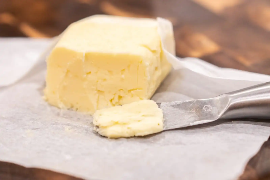 French cultured butter slab with flaky sea salt on wooden board
