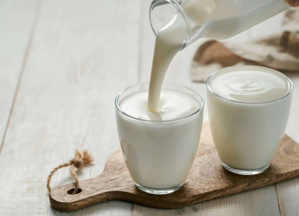 Pouring kefir into glasses – a probiotic-rich fermented milk drink popular in Europe.