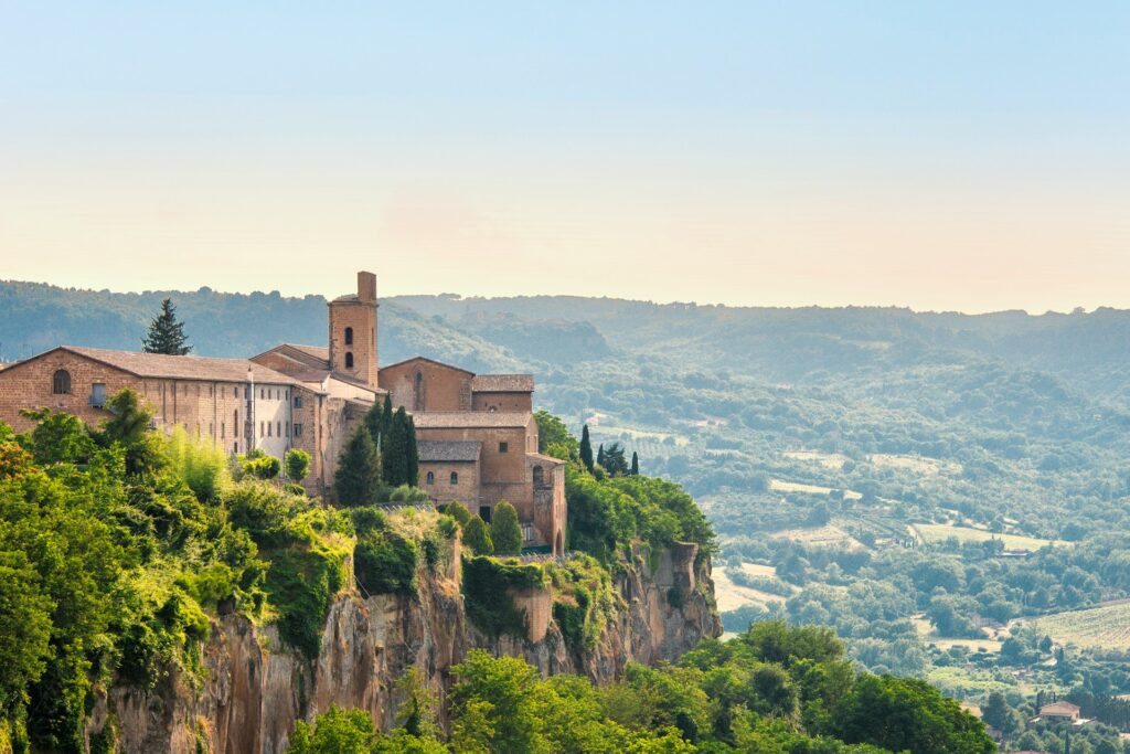 Cliffside view of Orvieto, Umbria with historic stone buildings and green rolling hills, featured in Stanley Tucci Searching for Italy Season 2 Episode 3