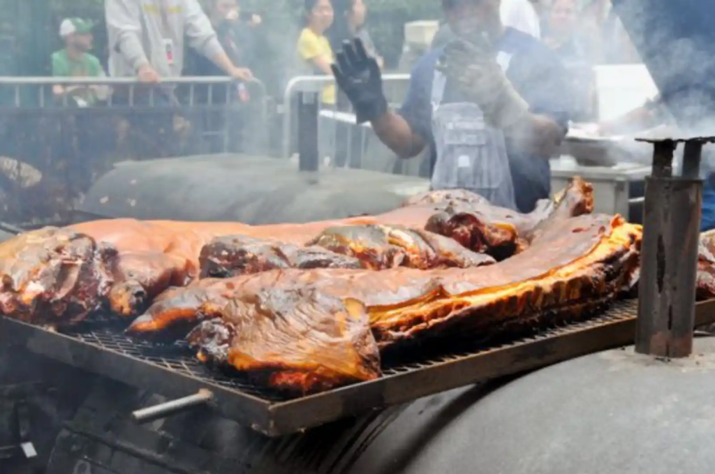 Whole hog slowly roasting over a smoky barbecue pit, representing traditional North Carolina-style fire-cooked barbecue.