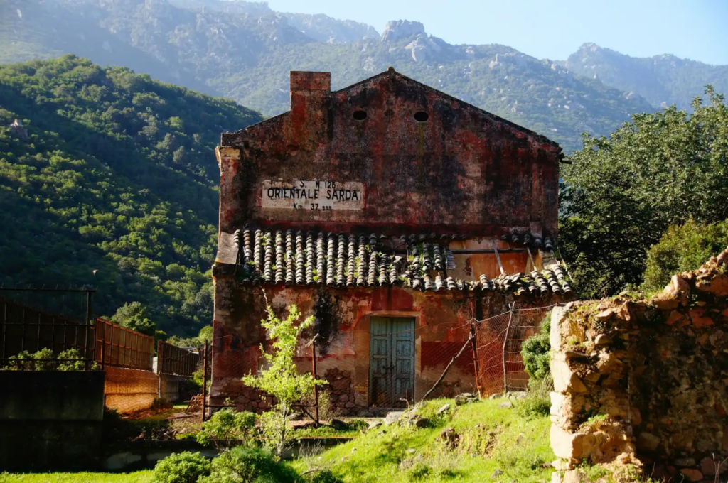 Old rural building with “Orientale Sarda” sign nestled in the mountains of Sardinia, Italy