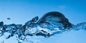 A clear splash of water against a blue background, symbolizing the fluidity, nourishment, and transformation at the heart of cooking.