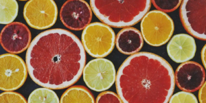 An assortment of sliced citrus fruits including oranges, grapefruits, limes, and lemons, arranged in an overlapping pattern.