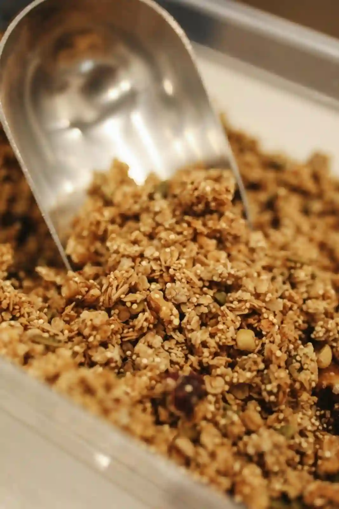 Homemade maple granola of oats, seeds and nuts with a metal scoop.