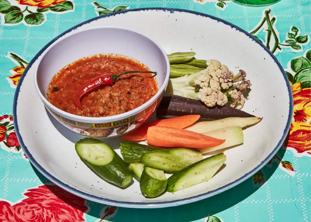 Plate of prahok ktis dip with assorted fresh vegetables.