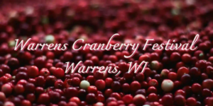 Close-up of fresh red cranberries with the overlaid title “Warrens Cranberry Festival, Warrens, WI.”